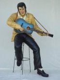 Elvis Presley sitting on stool playing guitar Elvis Presley sitting on stool playing guitar